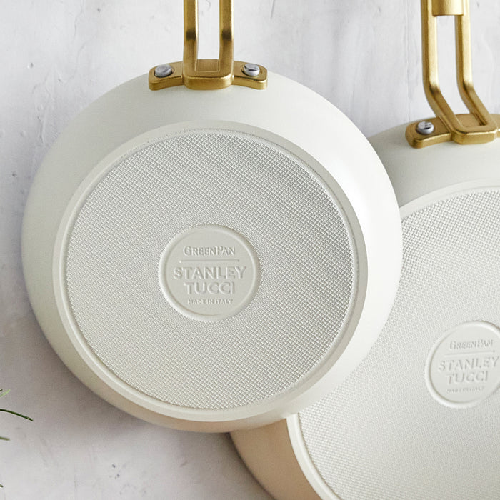 Two white ceramic nonstick frypans with gold handles and embossed details, set of 8-inch and 10-inch pans.