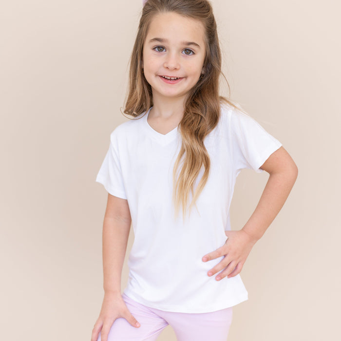 Young girl modeling the Toddler Leggings in Thistle with a white vneck