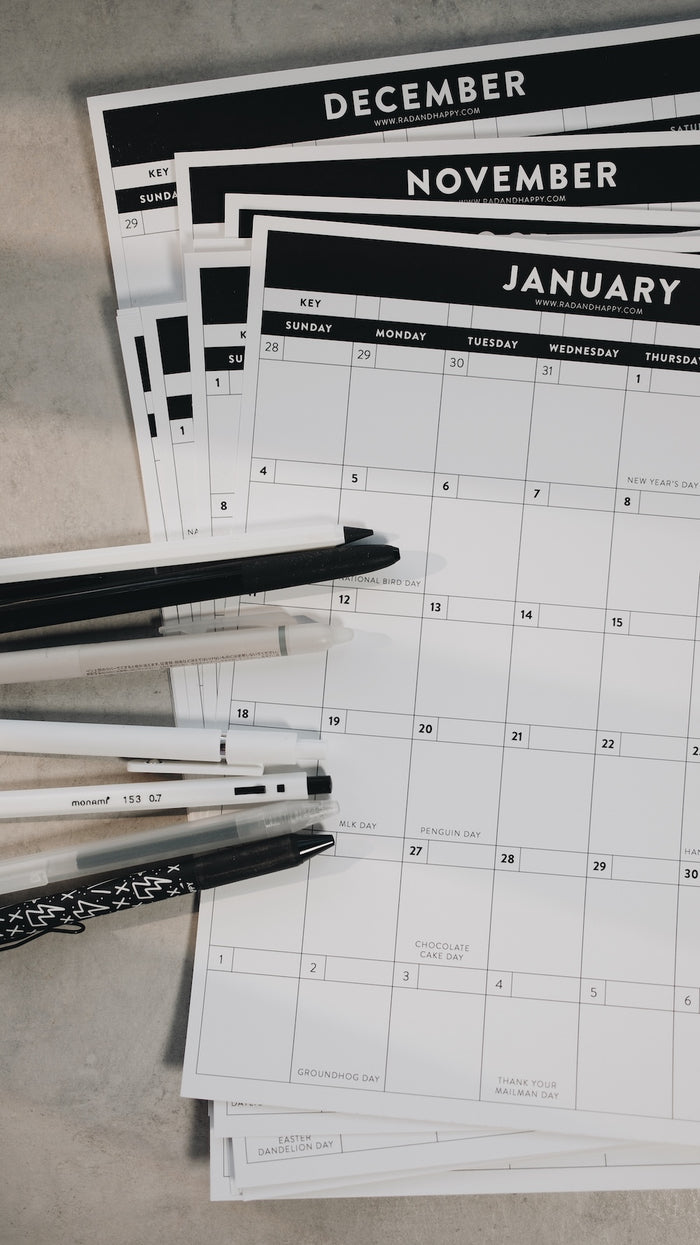 Calendars for December, November, and January with a pen on a light surface