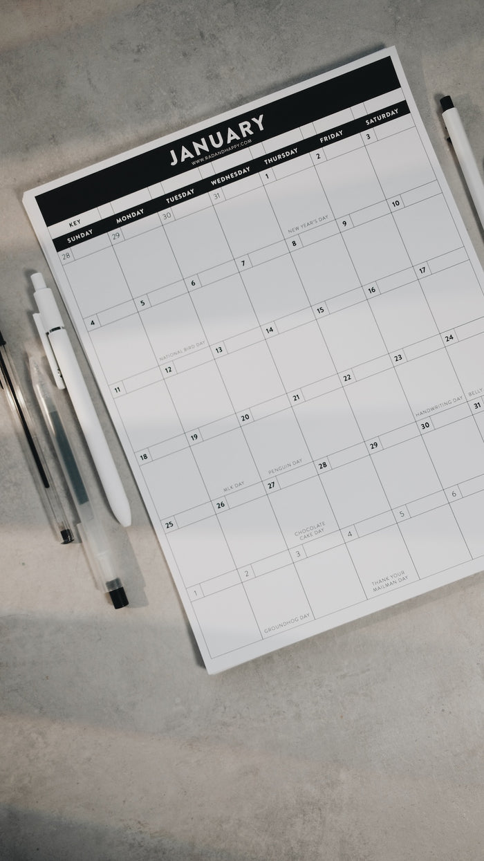 Calendar for January on a flat surface with pens beside it
