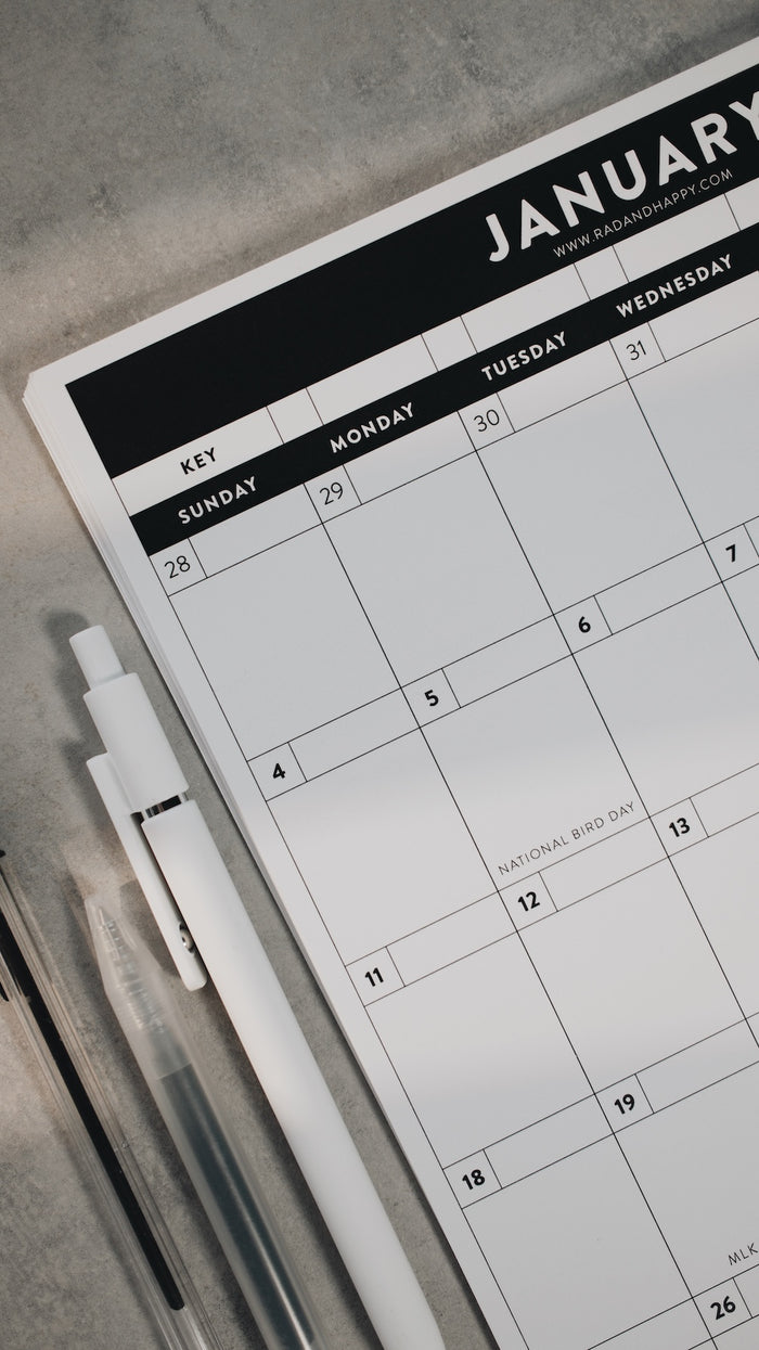 Calendar with a pen on a gray surface