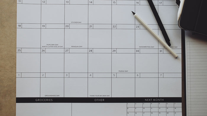 Pens laying on a calendar showing the bottom half of the page
