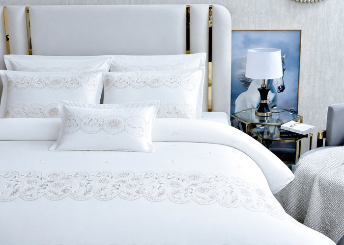 White queen duvet cover set with ornamental embroidery on duvet front and coordinating pillowcases