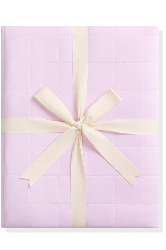Purple quilted blanket with a cream ribbon on a white background