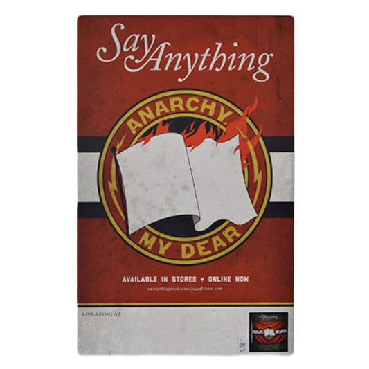An 11 x 17 red Say Anything “Anarchy, My Dear” poster features a burning white flag inside a circular emblem. Bottom text: “Available in stores + online now.”.
