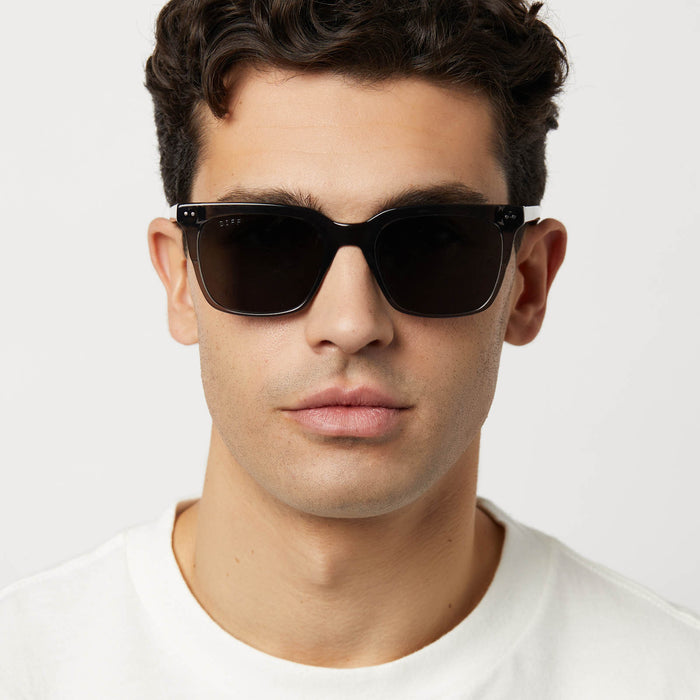 on model - male wearing diff eyewear featuring the billie xl square sunglasses with a black smoke crystal frame and grey polarized lenses front view