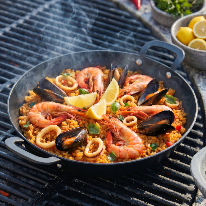Seafood paella with shrimp and mussels cooking in a black carbon steel pan on a grill.