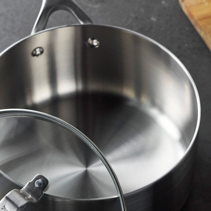 Stainless steel saucepan with glass lid on a dark countertop, 3-quart size, single piece.
