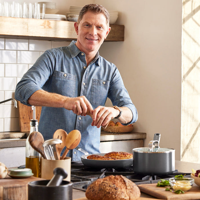 Person grinding pepper into food in a graphite Bobby Flay by GreenPan 10-inch ceramic nonstick frypan.