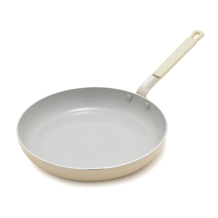 Cream ceramic 12-inch frypan with a chef-style handle on a white background.