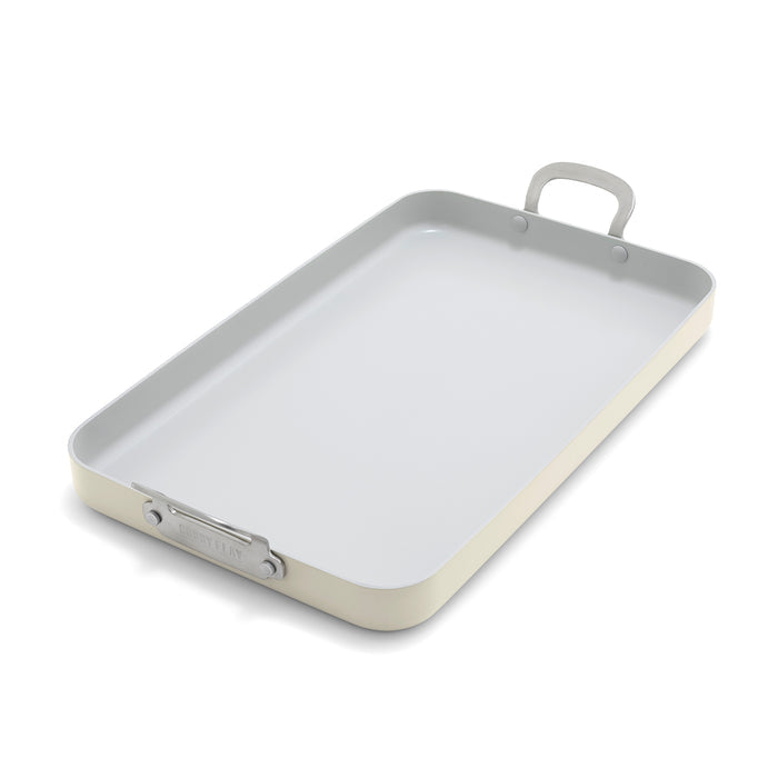 Cream double burner griddle with diamond-patterned ceramic cooking surface and stainless steel handles.