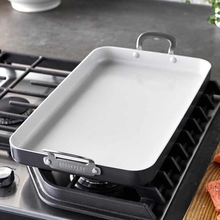 Graphite ceramic double burner griddle on a stovetop, 18x11 rectangular design with handles.