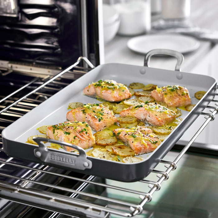 Salmon fillets and potatoes on a GreenPan double burner griddle, garnished with fresh herbs.