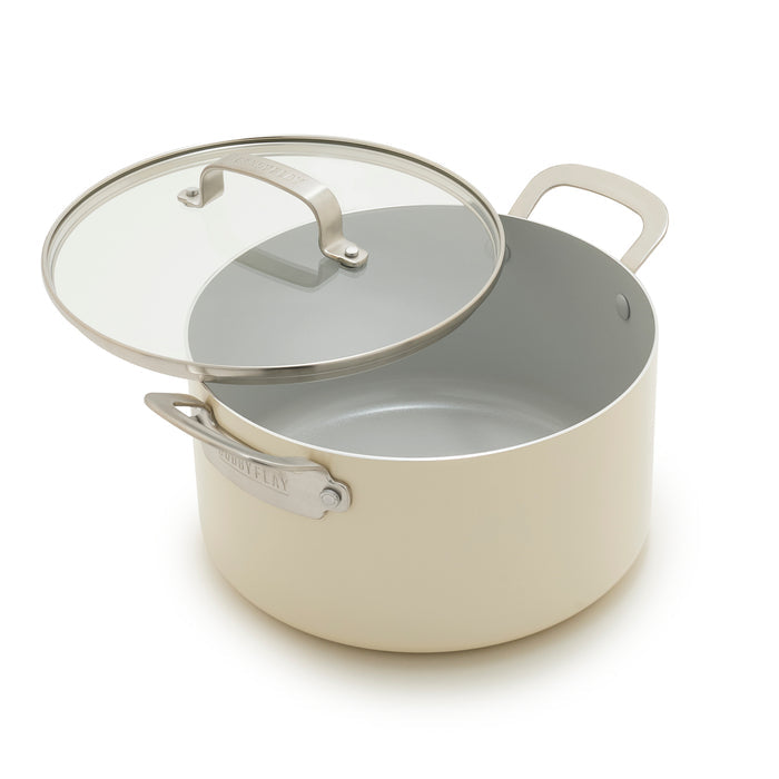 Cream 6-quart stockpot with handles and a slightly open lid on a white background.