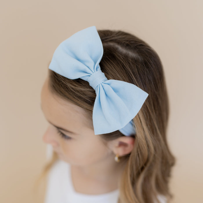 Close up of the Bow Headband in Breeze shown in a girls hair