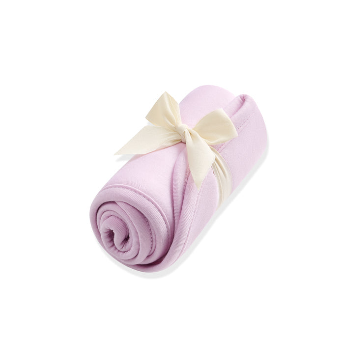Rolled-up purple burp cloth with a white bow on a white background