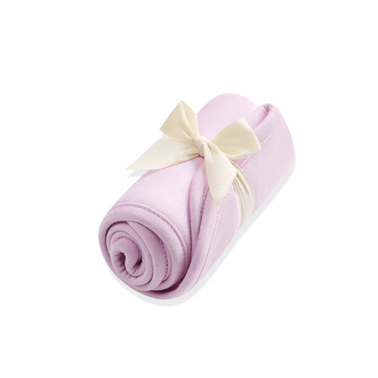 Rolled-up purple burp cloth with a white bow on a white background