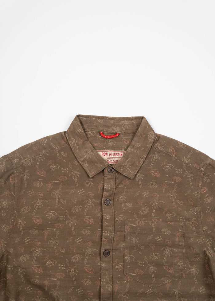 Brown button-up shirt with palm tree pattern, featuring a front pocket and collar. Iron & Resin label visible inside.