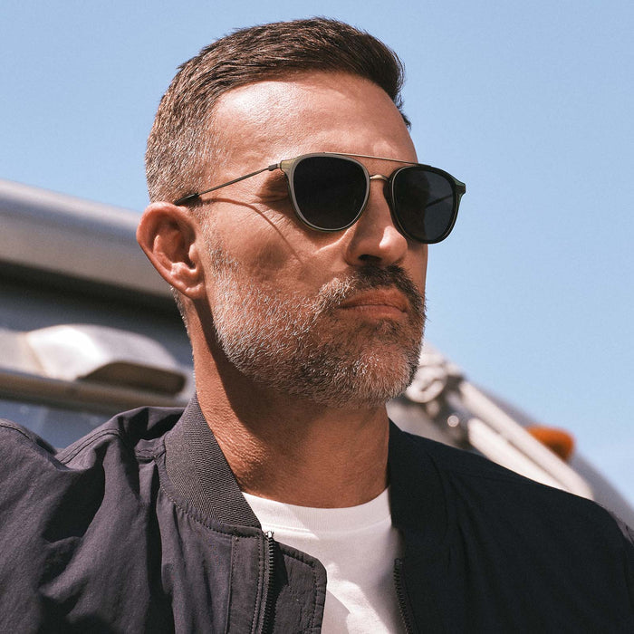 lifestyle - male wearing diff eyewear featuring the camden aviator sunglasses with a dark olive crystal frame and g15 polarized lenses angled view