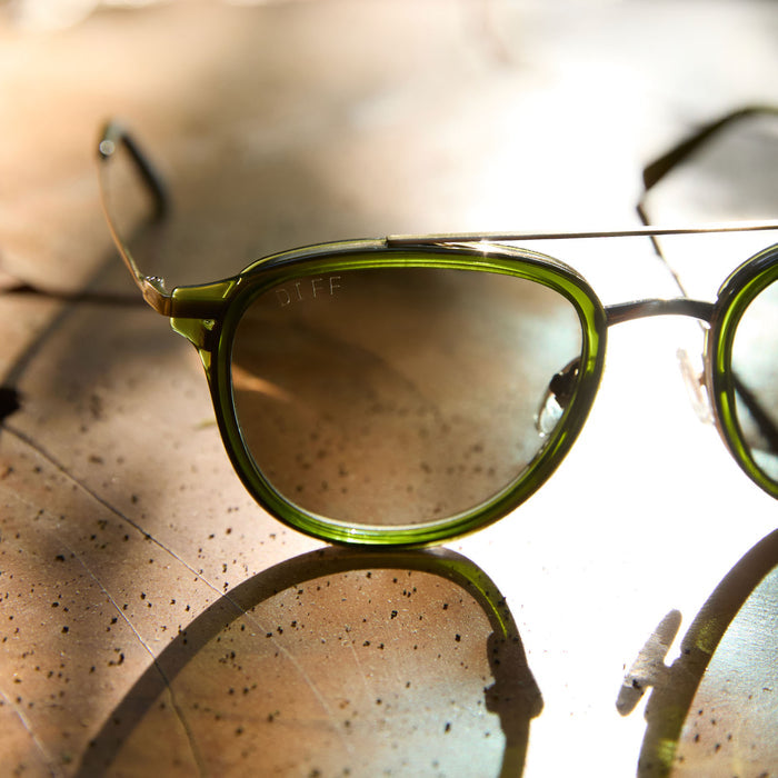 flay lay of diff eyewear featuring the camden aviator sunglasses with a dark olive crystal frame and g15 polarized lenses detailed view