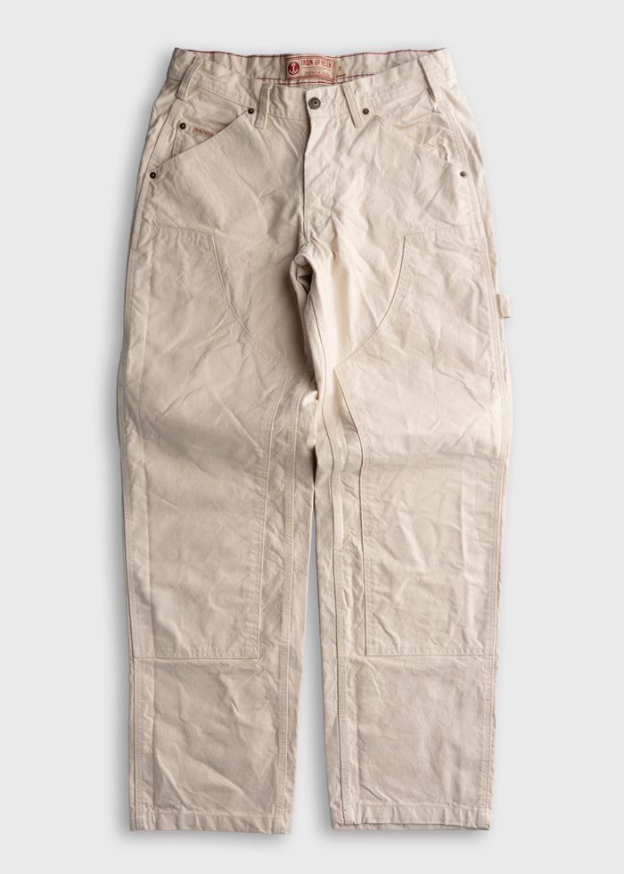 Cream-colored work pants with reinforced stitching and multiple pockets, laid flat on a white background.