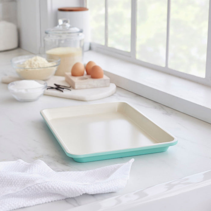 GreenLife ceramic nonstick cookie sheet set, 13 x 9, on a kitchen counter with baking ingredients nearby.