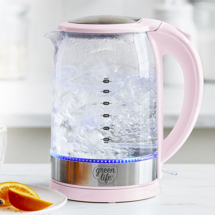 Pink glass electric kettle with 1.7L capacity and blue LED light on base, shown on a kitchen counter.