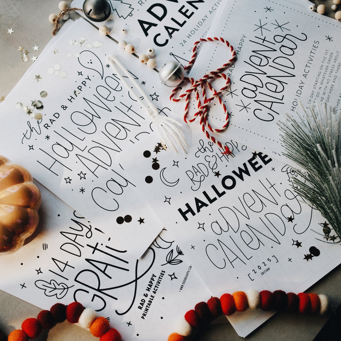 Papers on a light gray surface with a silver bell and red garland laid on the pages