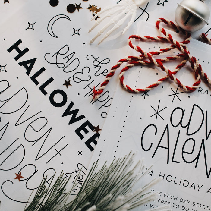Closer up picture of advent calendar pages laid out with holiday decorations