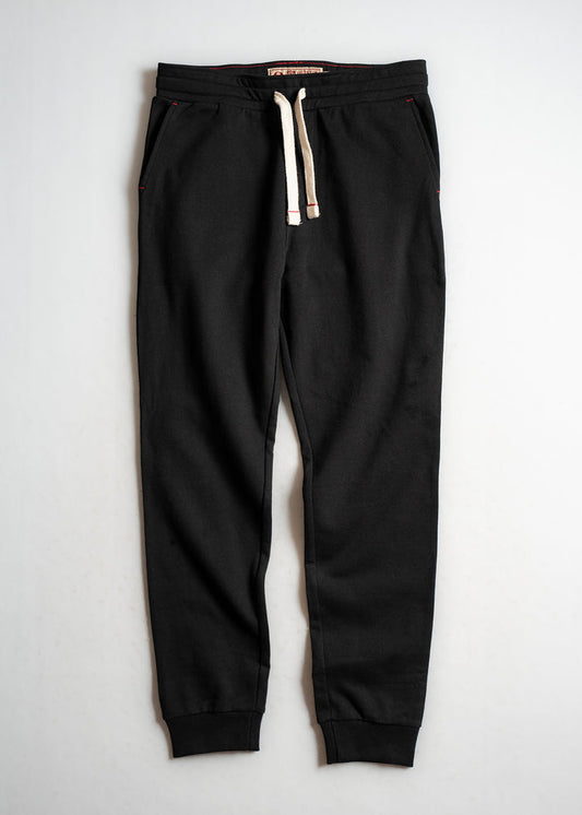 Black jogger pants with white drawstring, elastic cuffs, and side pockets, laid flat on a light background for display.