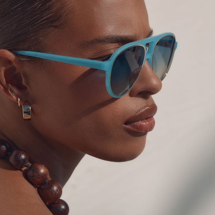 lifestyle - female wearing iconica x diff eyewear pia oversized aviator sunglasses with a parasido blue acetate frame and paradiso blue polarized lenses detailed view