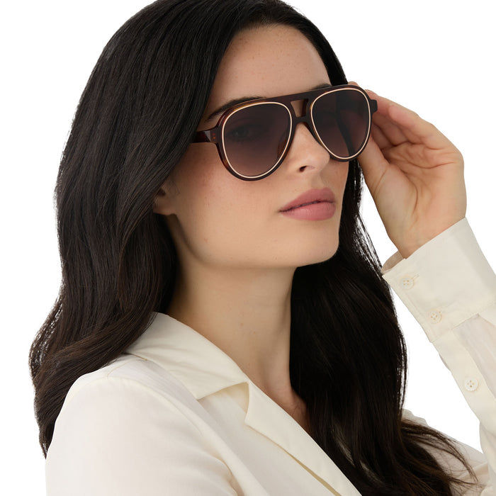 on model - female wearing iconica featuring the pia aviator sunglasses with a salted caramel tortoise frame and brown gradient polarized lenses angled view