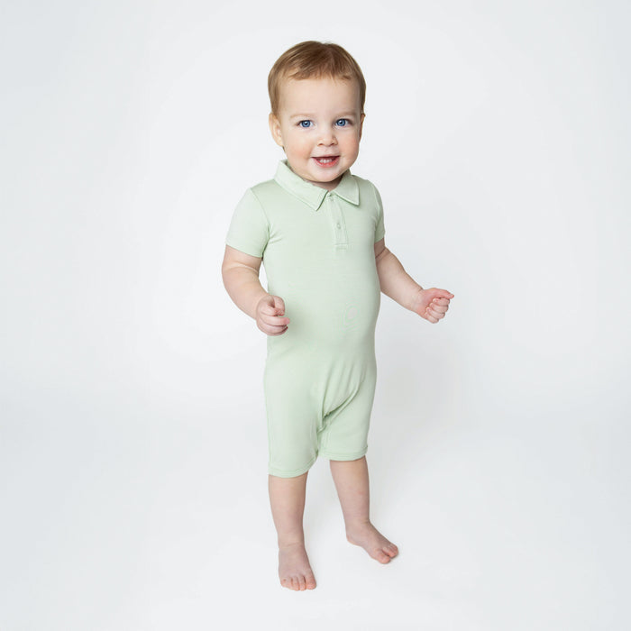 Young toddler standing in front of a white background wearing the Polo Shortall in Basil