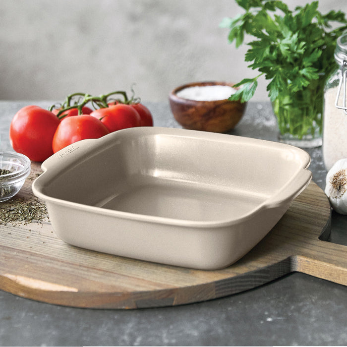 Taupe ceramic 8x8 square baker filled with tomatoes, greens, and spices.
