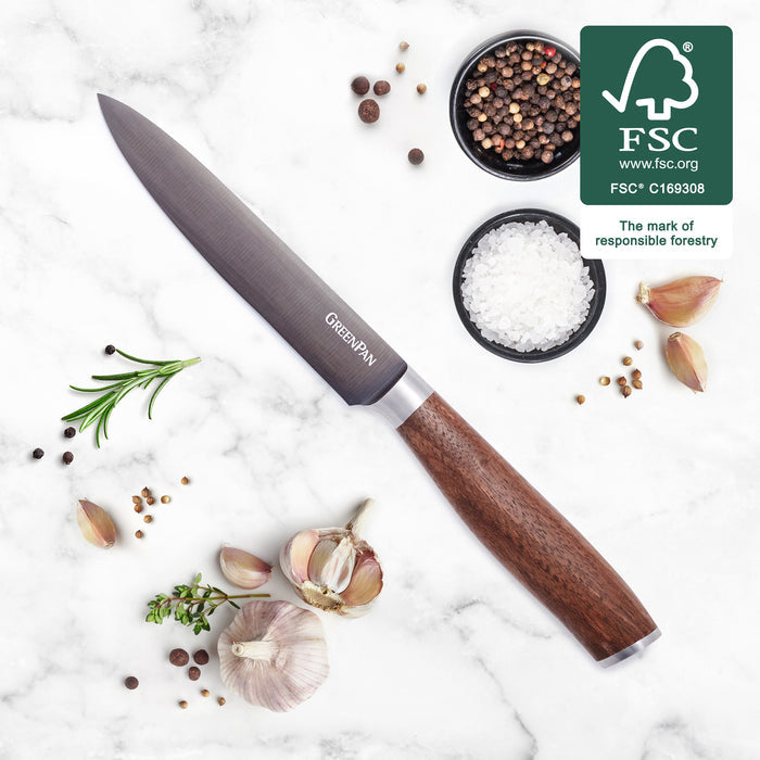 5-inch utility knife with walnut handle on marble, surrounded by garlic, herbs, salt, peppercorns, and FSC logo.