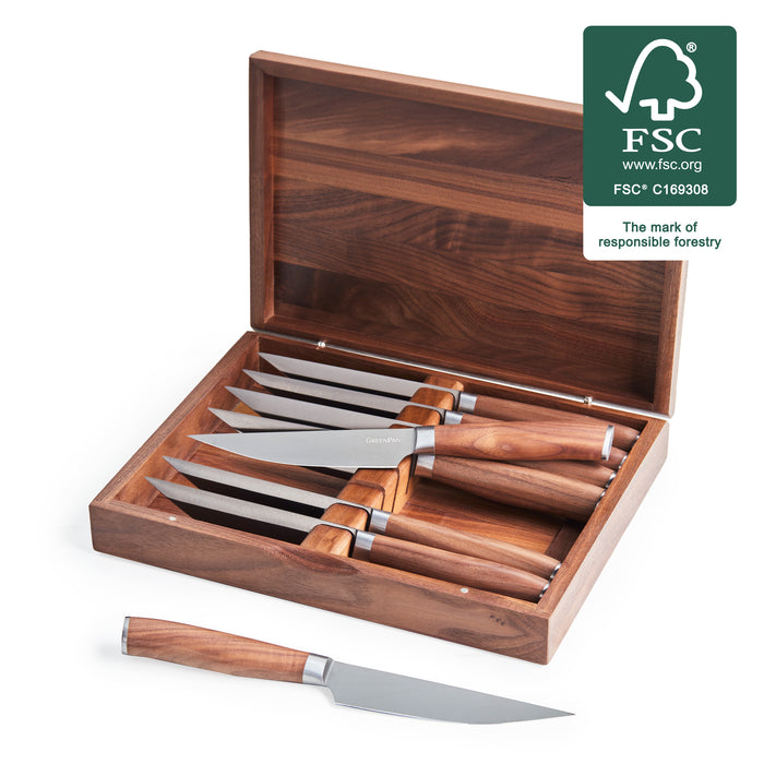 Set of 8 steak knives with titanium blades and walnut wood handles arranged on a table.
