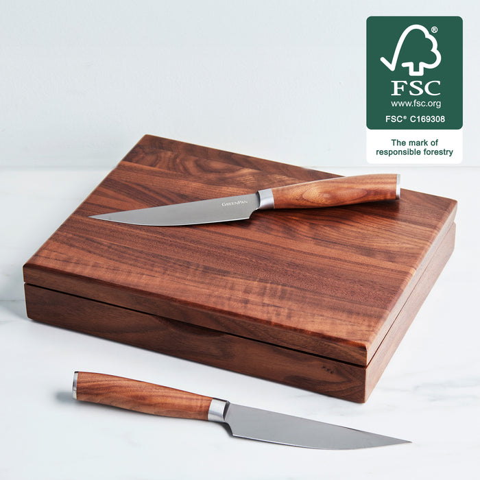 Eight titanium steak knives with walnut handles arranged in a set.