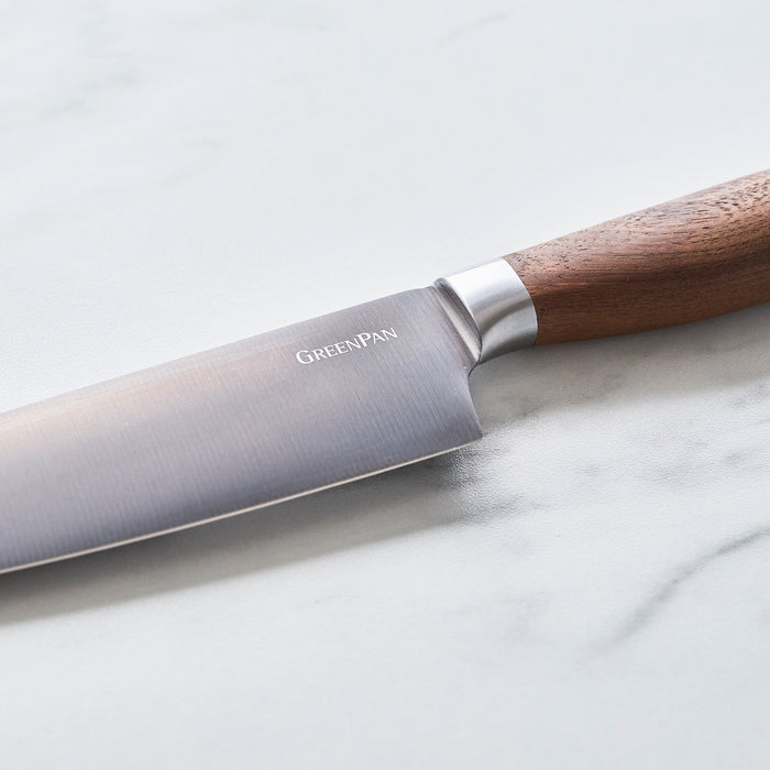Set of 8 steak knives with titanium blades and walnut handles arranged side by side.