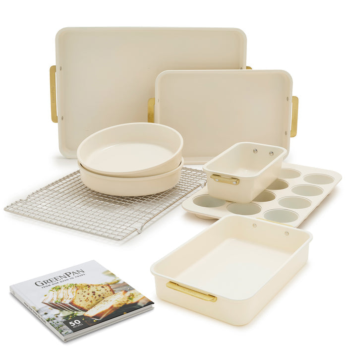 Cream-colored 8-piece bakeware set with aluminized steel pans, muffin tin, trays, cooling rack and gold handles.