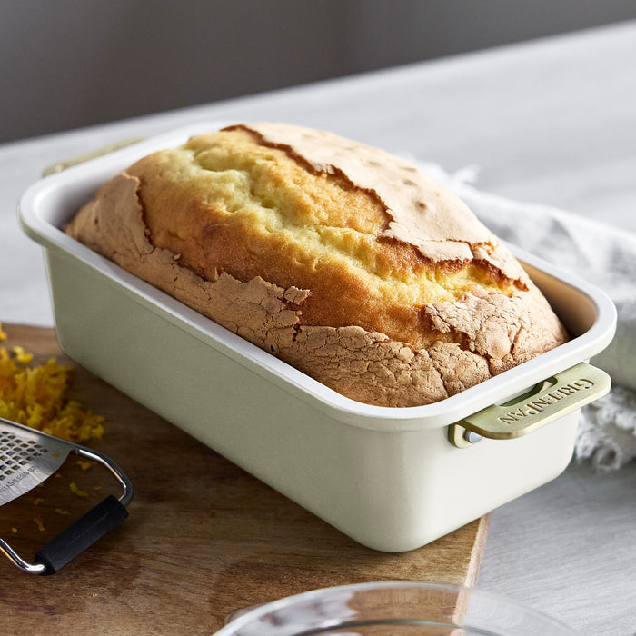 Cream-colored Reserve Bakeware loaf pan with a freshly baked loaf, part of the visible 8-piece set.
