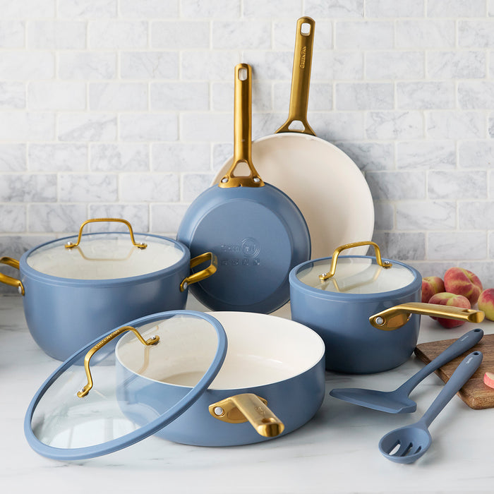 Set of blue cookware with gold handles on a kitchen counter.