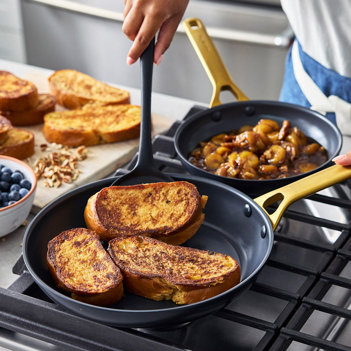 Person cooking French toast in a black frypan on a stove