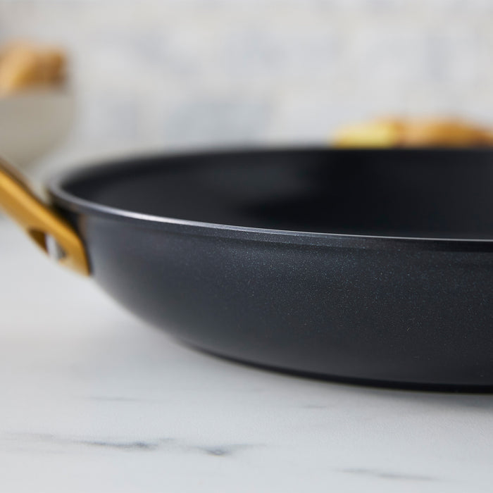 Black frying pan on a marble surface with a blurred background