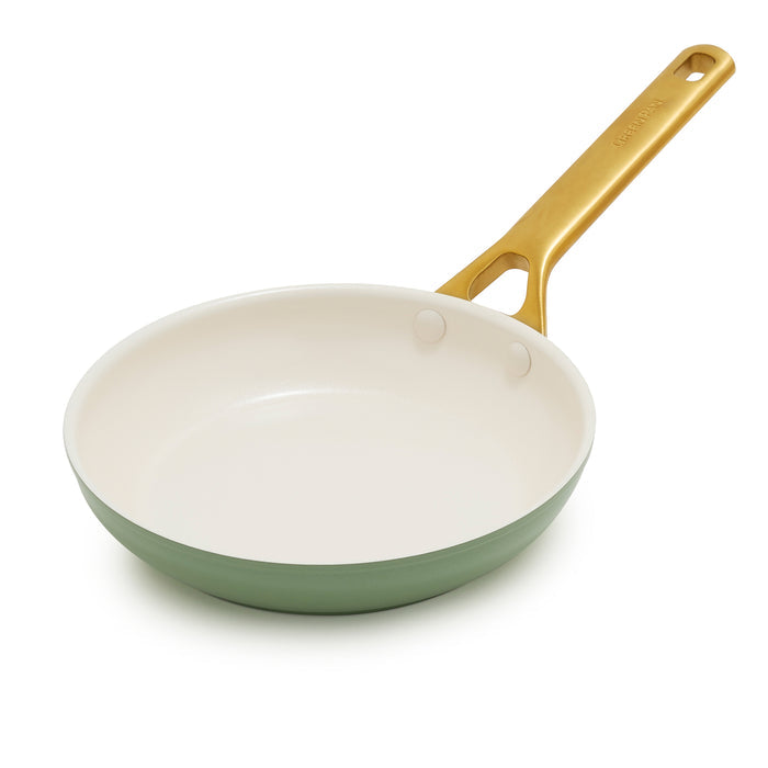 Sage green frying pan with a gold handle on a white background