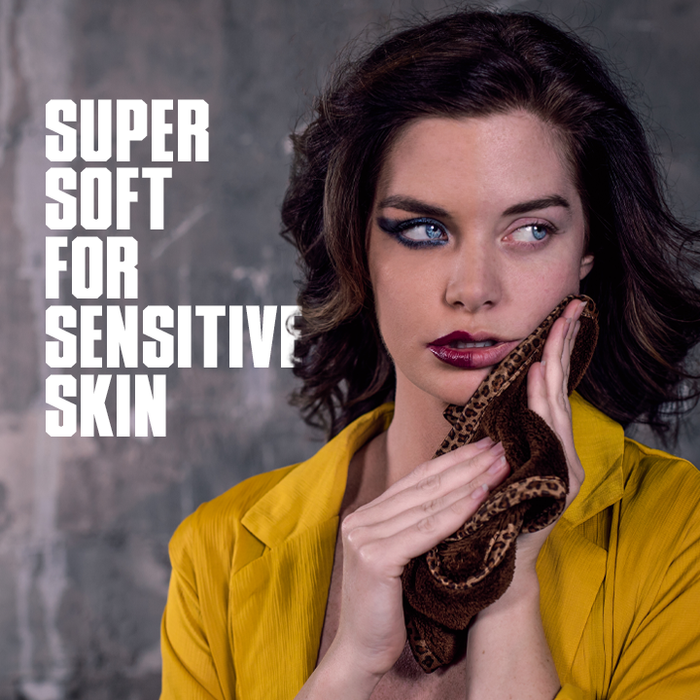 Woman holding a snake with text 'Super Soft for Sensitive Skin' on a gray background