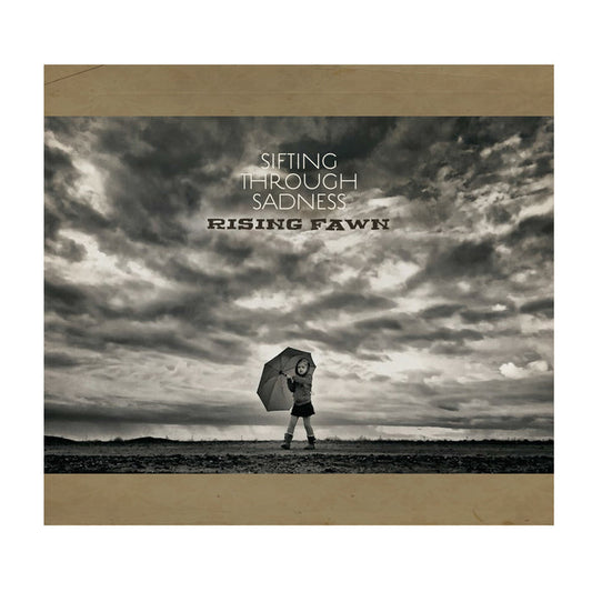 A child with an umbrella stands solo under a dramatic, cloudy sky. The text reads "Sifting Through Sadness" above and "Rising Fawn" below—striking black and white imagery, perfect as CD cover art or tracklist inspiration for Rising Fawn.