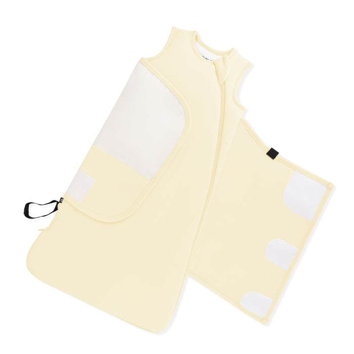 Adjustable velcro swaddle wrap shown on an unswaddled Sleep Bag Swaddler in Chamomile 1.0