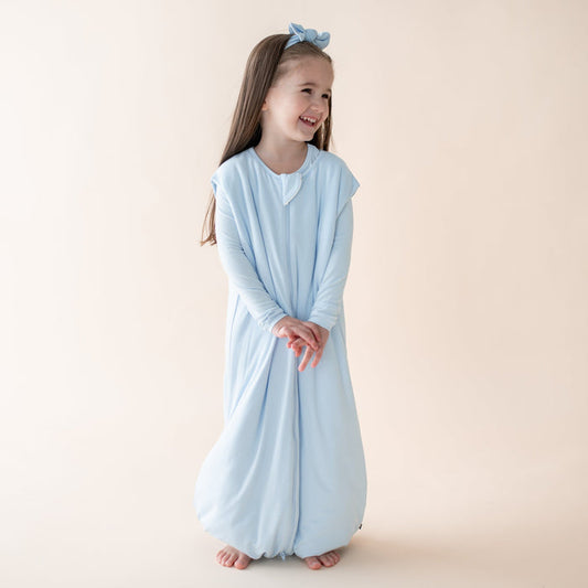 Child wearing a light blue sleep bag walker