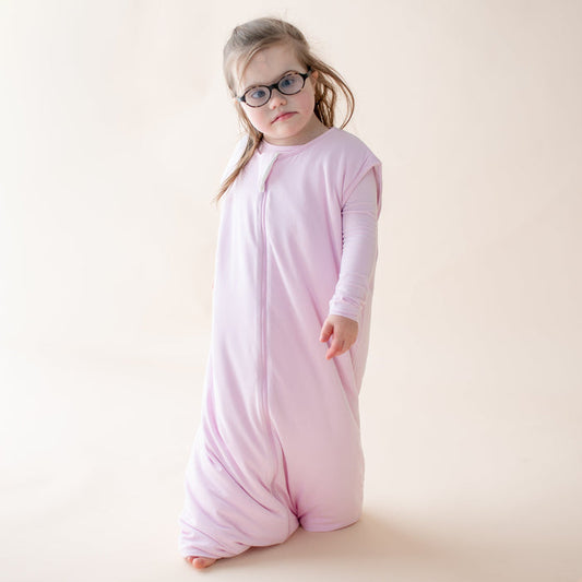 Child wearing a light purple sleep bag walker