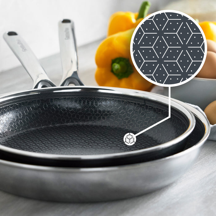 Two ceramic nonstick frypans with a geometric pattern, set of two, peppers and eggs nearby.